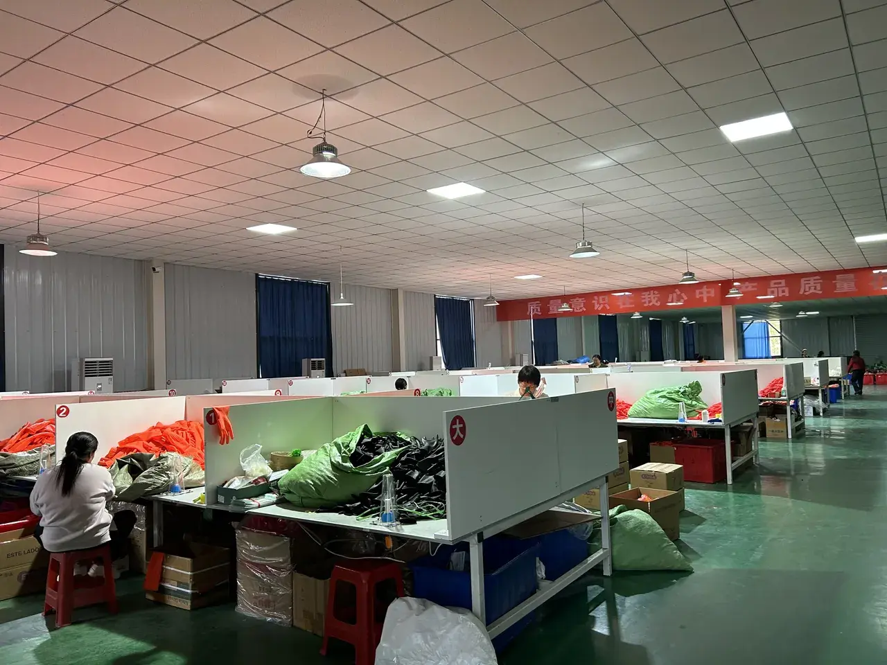 Factory packing center with workers preparing gloves for shipment